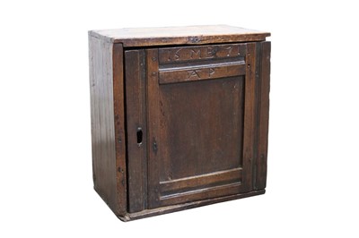 Lot 1422 - 17th century oak spice cupboard, the panelled door dated 1671 and inscribed with initials, the interior with divisions, 40cm wide x 24cm deep x 43cm high