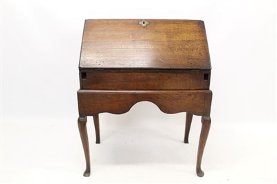 Lot 1445 - George II oak desk on stand, fitted interior and well enclosed by a fall-front, on stand with shaped apron on club legs on pad feet, 74cm wide