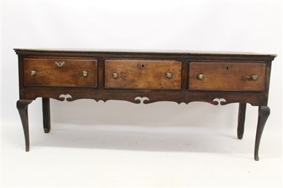 Lot 1460 - Early 18th century oak dresser base with three drawers above a cut-out shaped apron on cabriole legs, 182cm wide