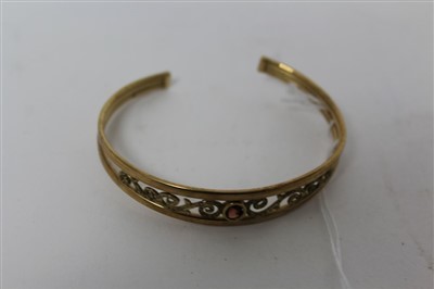 Lot 3357 - 9ct gold bangle set with a garnet