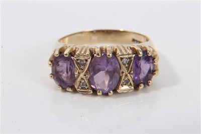 Lot 3378 - Ladies' 9ct gold amethyst and diamond ring with three oval mixed cut amethysts interspaced by four small diamonds, in claw setting. Ring size M