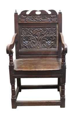 Lot 1470 - Rare mid-17th century carved oak Wainscott chair, the panel back with fret cresting and relief-carved with narrow frieze of hogs heads issuing foliate ornament, rectangular foliate carved panel bel...