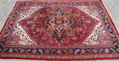 Lot 1669 - Large Indian Heriz-style wool pile carpet on red ground 353cm x 254cm