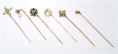 Lot 565 - Six Edwardian stick pins – to include an aquamarine, diamond and seed pearl stick pin, pale-yellow old cut diamond stick pin and four others