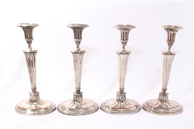 Lot 411 - Set of four early 19th century silver plated candlesticks with fluted tapering stems