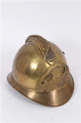 Lot 581 - French brass fire helmet, an Essex fire brigade helmet and a London fire brigade helmet (4)