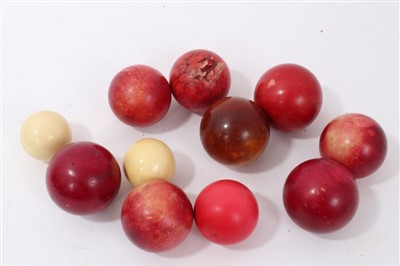 Lot 634 - Nine  Edwardian stained ivory billiard balls and two small ivory balls