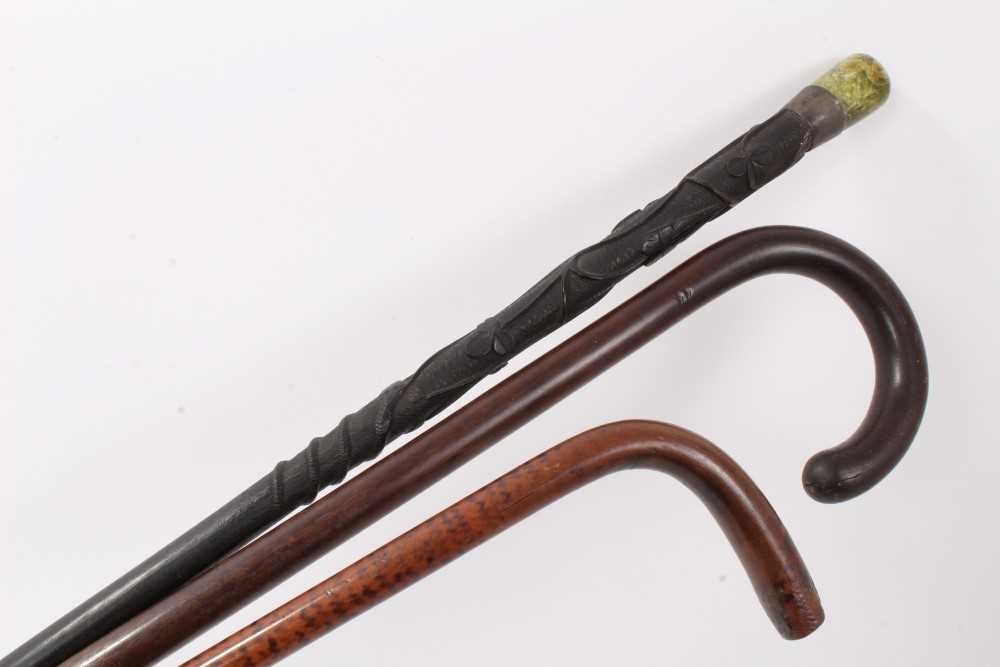 Lot 635 - Unusual Irish carved bog oak walking stick, 19th century patridgwood cane and another cane