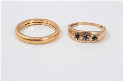 Lot 3215 - Yellow metal wedding ring and a gold (9ct) sapphire three stone ring (2)