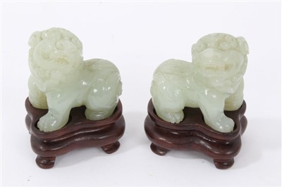 Lot 655 - Pair of carved jade or green hardstone figures of temple lions