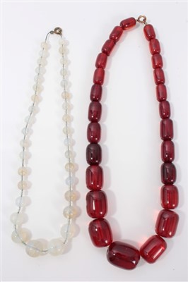 Lot 3216 - 1930s simulated cherry amber bead graduated necklace and a 1930s opaline bead necklace