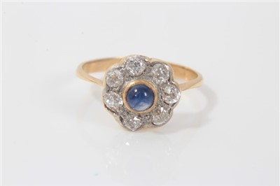 Lot 3232 - Edwardian sapphire and diamond cluster ring with a central blue sapphire cabochon surrounded by seven old cut diamonds on yellow metal shank, ring size K