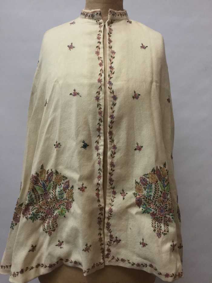 Lot 3055 - Victorian fine cream wool cape with embroidered floral motifs and running floral border. Lined with cream silk satin. Possibly Indian.