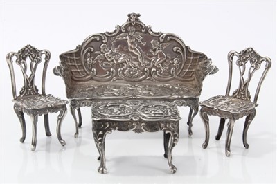 Lot 2718 - Edwardian miniature silver suite of silver repoussé table and two chairs, Levi & Salaman, Birmingham 1903 / 1905, in the the Rococo style, the chairs 5.5cm high