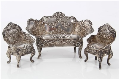 Lot 2722 - 19th century Continental miniature silver three piece suite of Rococo style furniture, comprising twin seater settle and two side chairs, floral embossed, import marks for London 1898, the settee 5...