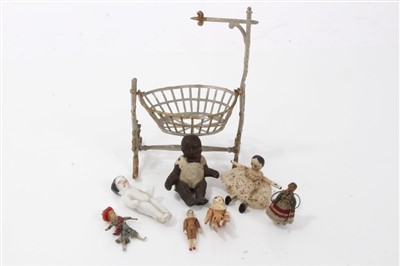 Lot 2742 - Early 20th century miniature metal cradle, with porcelain baby within, 9cm high, together with tiny Victorian articulated doll and other miniature antique dolls