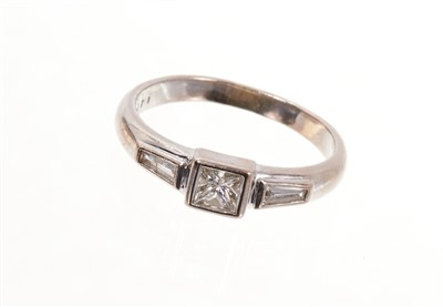 Lot 481 - 18ct white gold diamond ring with a princess cut diamond flanked by tapered baguette cut diamonds to each shoulder.