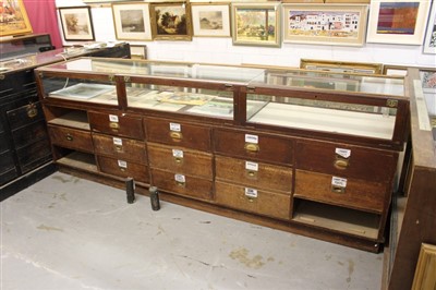 Lot 1392 - Antique oak framed glazed shops display counter, narrow form, with three rear hinged doors,  275cm long x 55cm deep x 27cm high