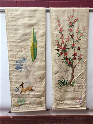 Lot 3081 - Pair 1950s hand embroidered wall hangings, one depicting a deer in landscape, the other a cherry blossom tree, both with makers initials and date- D.L.N 1951, on wooden rods.