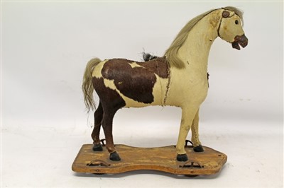 Lot 2772 - 19th century push-a-long horse with hide body, horse hair mane and tail, on wooden plinth with four metal wheels