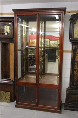 Lot 1399 - Early 20th century mahogany shop display cabinet, enclosed by two pairs of glazed doors on plinth base, 106cm wide x 46cm deep x 212cm high