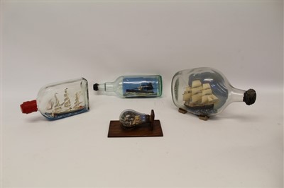 Lot 3583 - Ships in bottles to include Yarmouth steam drifter, two galleons under sail and a miniature harbour scene with lighthouse in a light bulb (4)