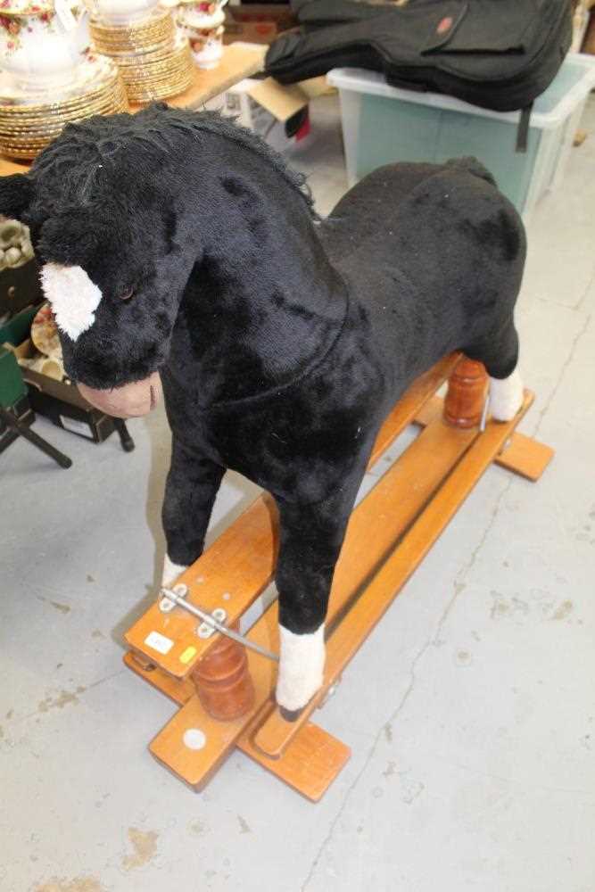 Lot 476 - Rocking horse with plush covering on wooden cantilever base.