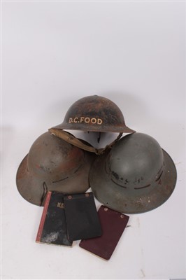 Lot 582 - Second World War British Military MK II tin helmet, in black painted finish, marked D.C. Food together with two further tin helmets and military related ephemera