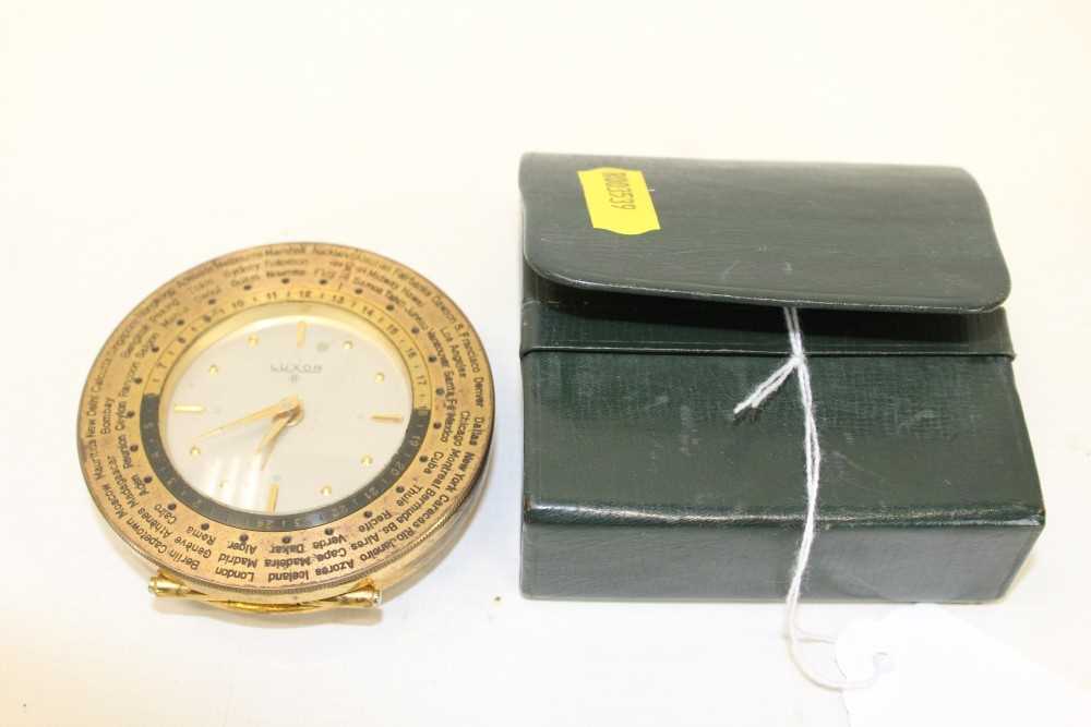 Lot 3558 - Luxor eight day travelling alarm clock, with silvered dial gold coloured hands and hour markers, in a brass case with hinged stand and international time scale, together with an outer leather case.