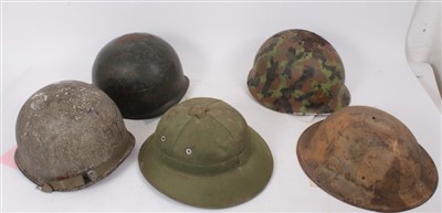 Lot 591 - Group of various military helmets to include American Army M1917 steel helmet, two Second World War American M1 steel helmet, Vietnamese Army pith helmet, and an Argentinian M1 steel helmet (5)