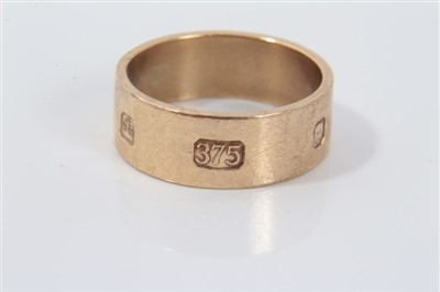 Lot 3265 - Gold (9ct) thick banded ring with large hallmark decoration, size O.