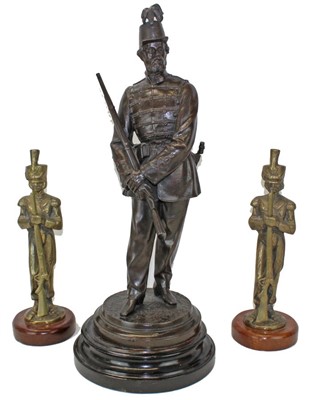 Lot 3617 - Victorian spelter figure of a soldier in the Rifle Volunteers, mounted on a turned wooden plinth, together with a pair of brass military figures. (3)