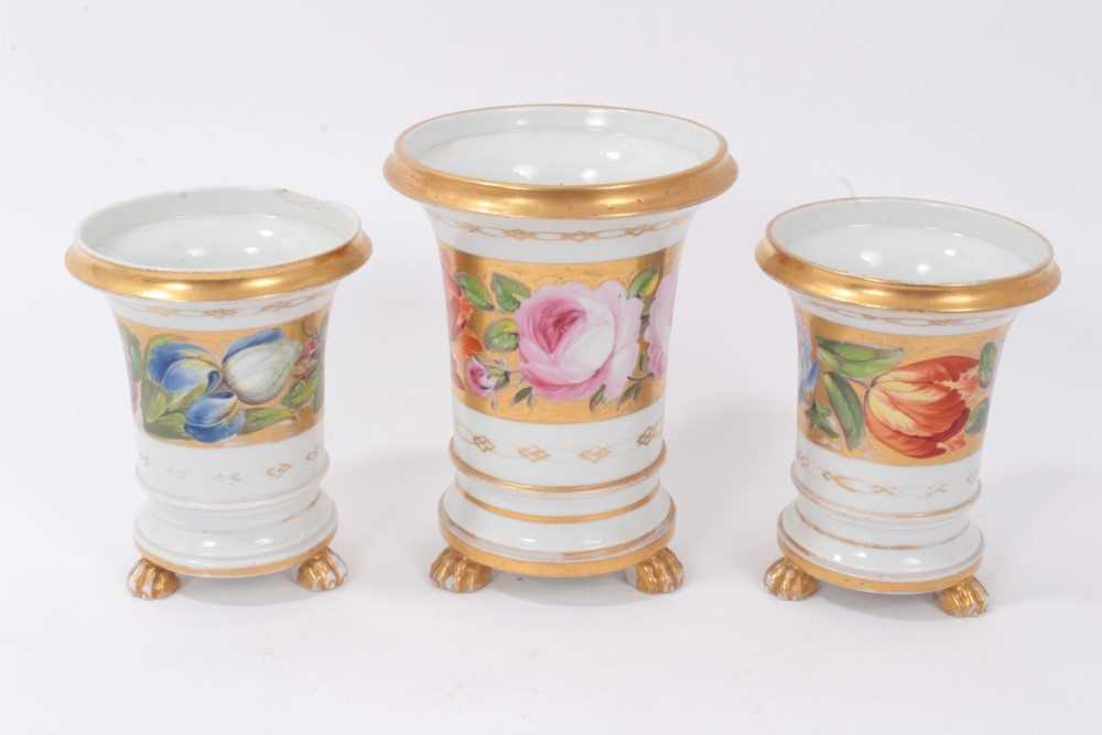 Lot 79 - Garniture of three early 19th Century vases of flared cylindrical form with polychrome painted floral band including pink roses on gilt ground, raised on paw feet comprising central vase 14cm high...