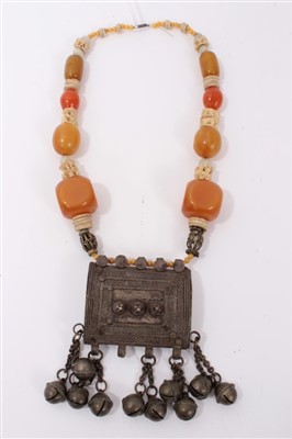 Lot 3411 - Old Turkmen necklace with bells suspended from a plaque, on a bone and simulated amber bead necklace