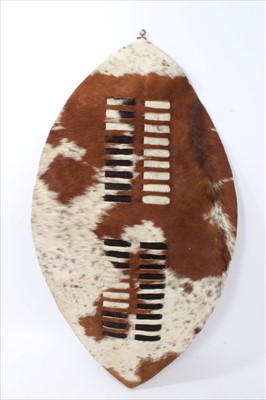 Lot 714 - An African cow skin shield, spear and knobkerry