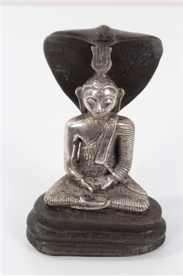 Lot 860 - Antique silver Buddha, Kandy type, the seated figure with flaming crest, on bronze cobra throne