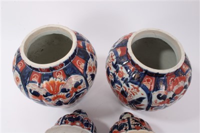 Lot 21 - Pair of Japanese Imari ovoid vases and domed covers