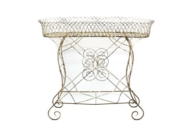 Lot 1311 - Antique wirework jardinière stand, of oval form on x-frame supports with scrolled terminals, 108cm wide