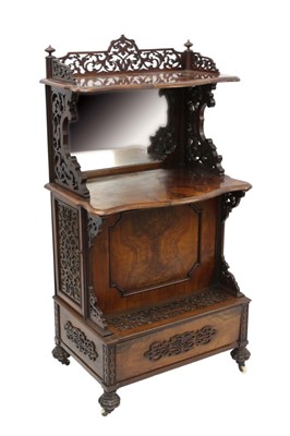 Lot 1315 - Mid 19th century figured walnut whatnot, with pierced gallery shelf and mirror back tier, enclosed by fret carved door to each side with projecting fall front below, raised on lobed feet and castor...