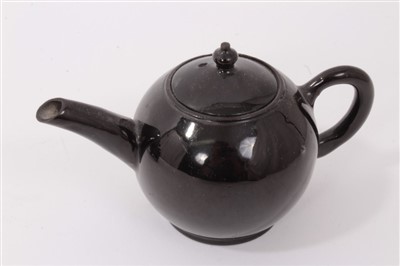 Lot 114 - Four 18th century Jackfield brown glazed pottery small teapots -one with cooked handle and raised on legs (4)