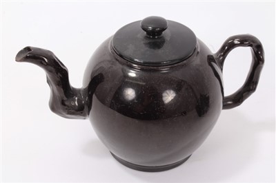 Lot 114 - Four 18th century Jackfield brown glazed pottery small teapots -one with cooked handle and raised on legs (4)
