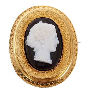 Lot 537 - Victorian carved sardonyx cameo brooch, finely carved depicting a classical female bust in profile, the oval gold mount with applied filigree decoration and glazed locket compartment to the reverse...