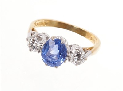 Lot 538 - Sapphire and diamond three stone ring with an oval mixed cut blue sapphire weighing approximately 1.80cts flanked by two brilliant cut diamonds weighing a total of approximately 0.60cts in claw set...