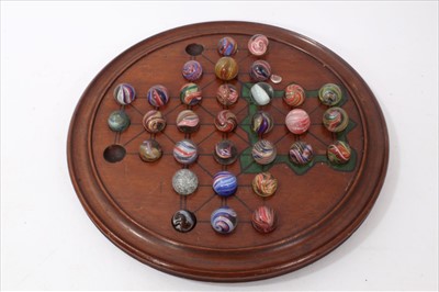 Lot 3530 - Victorian mahogany solitaire board and a collection of antique glass marbles