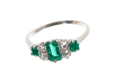 Lot 690 - Emerald and diamond ring with three step cut emeralds weighing approximately 0.60cts and four old cut diamonds in claw setting on platinum shank. Estimated total diamond weight approximately 0.30ct...