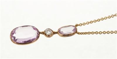 Lot 699 - Pink topaz and diamond pendant necklace with two oval mixed cut pink topaz and an old cut diamond, all in gold rub-over setting on gold trace link chain.