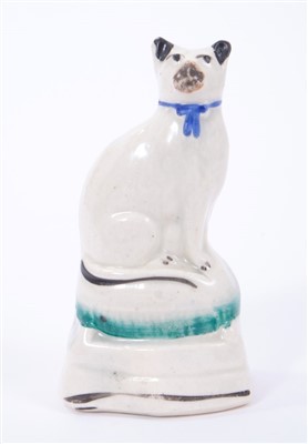 Lot 266 - Mid 19th century Staffordshire model of a cat, sparsely decorated in enamels