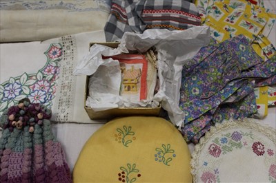 Lot 3073 - A quantity of table linens including embroidered and lace cloths, and mats, Linen table cloth with blue embroidered Oriental inspired design. \plus some 1950's aprons.