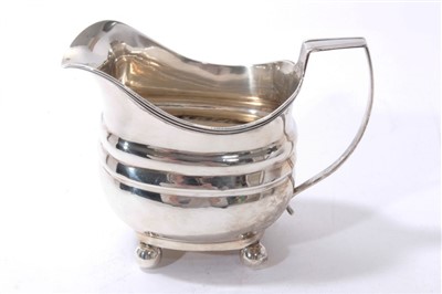 Lot 541 - George III silver cream jug of bellied form with reeded rim, angular handle, on four ball feet.