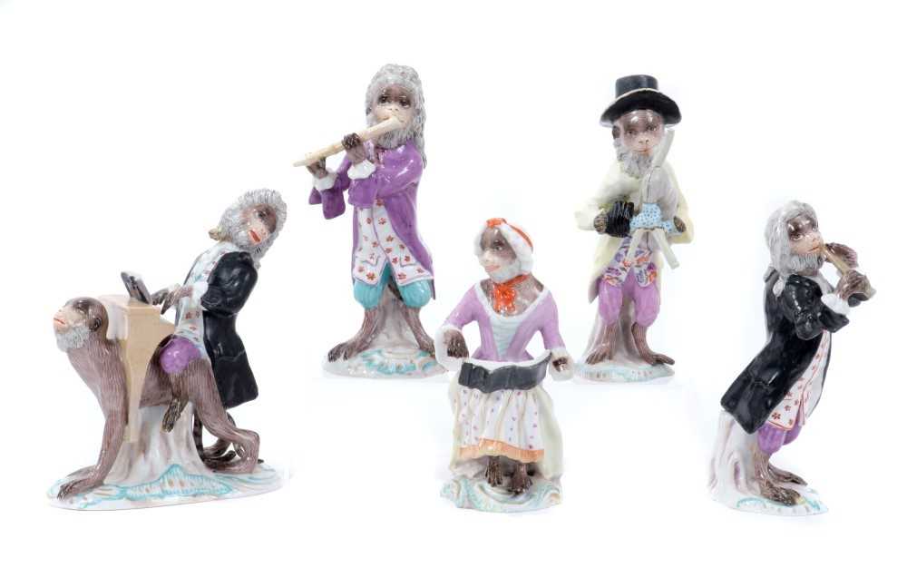 Lot 204 - Set of five late 19th century Dresden Monkey Band Figures, including piano player resting on monkey's back, bagpipe player, singer and flutists, on scrollwork rococo bases, some with underglaze blu...